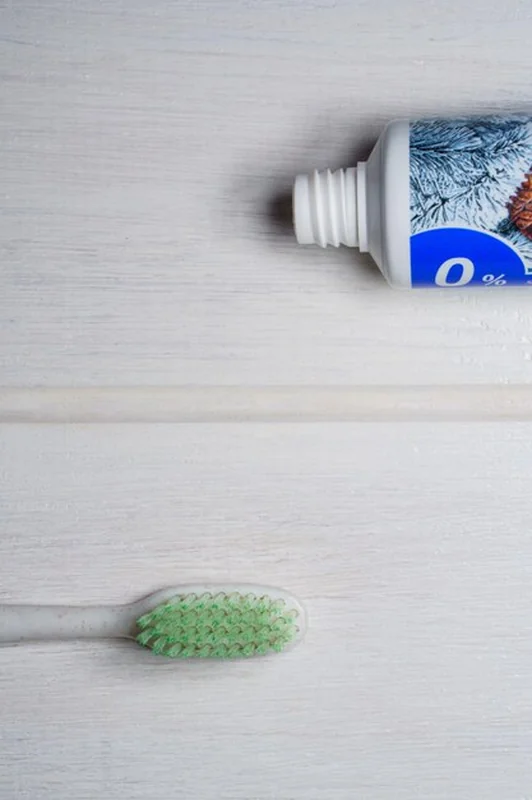 Tubka pasty do zębów ze szczoteczką na białym tle