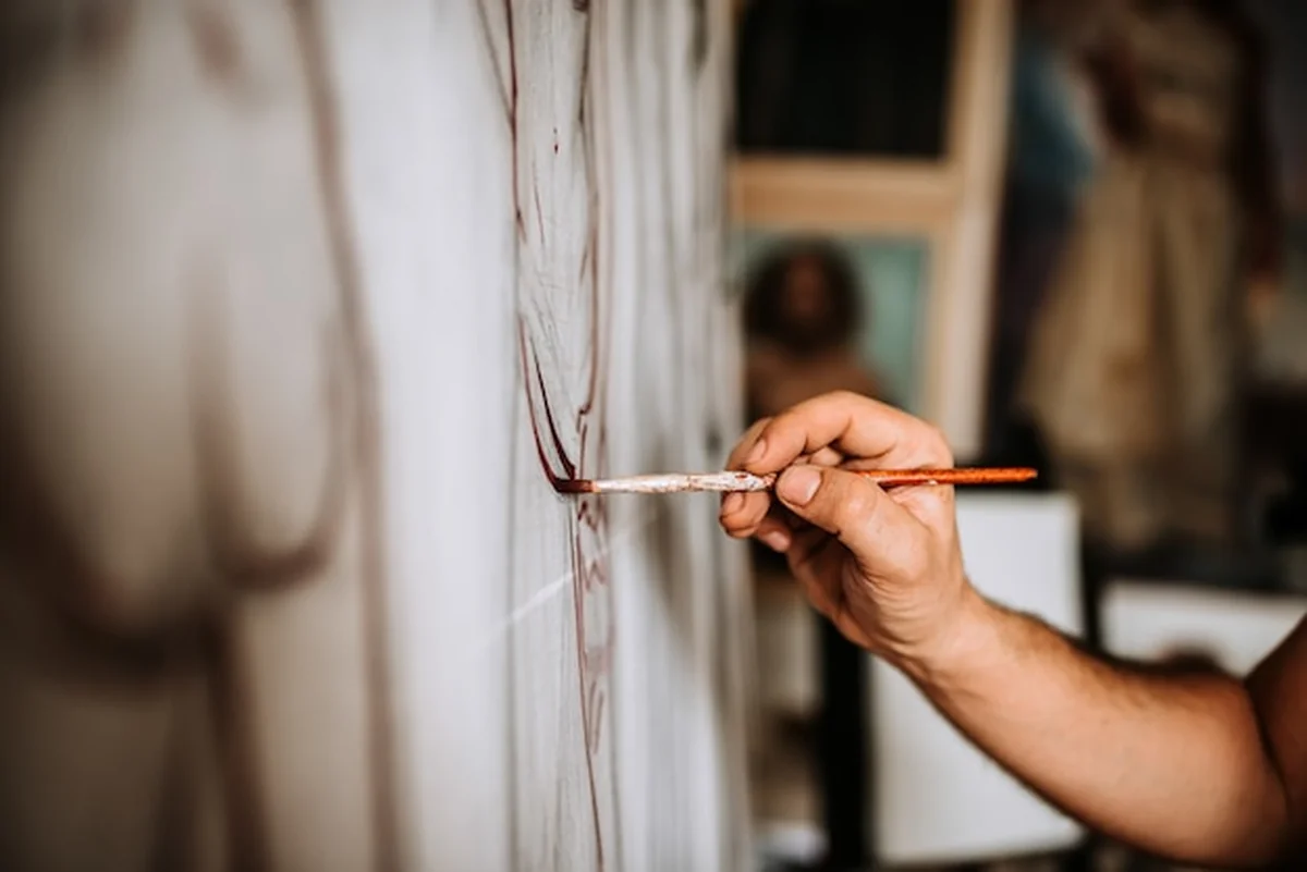 Malarz pracujący nad dziełami sztuki