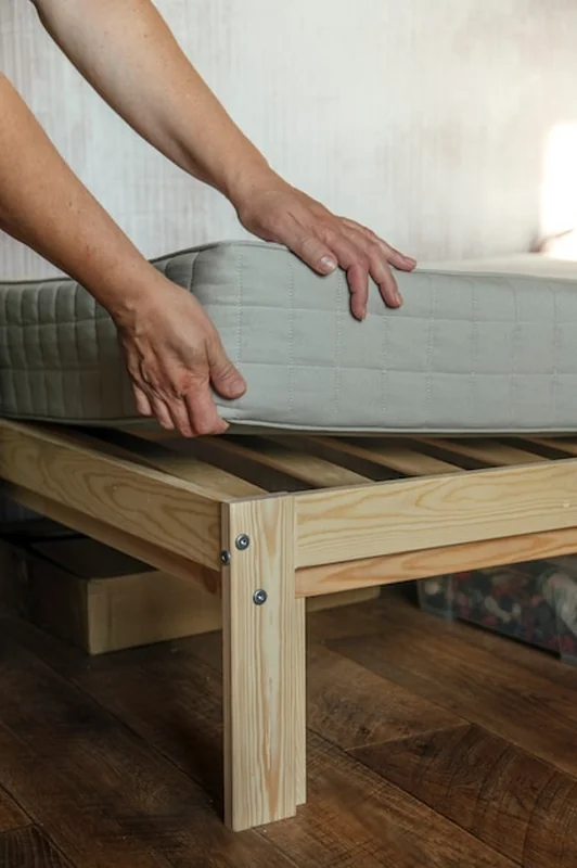 Kobieta kładzie materac na łóżku