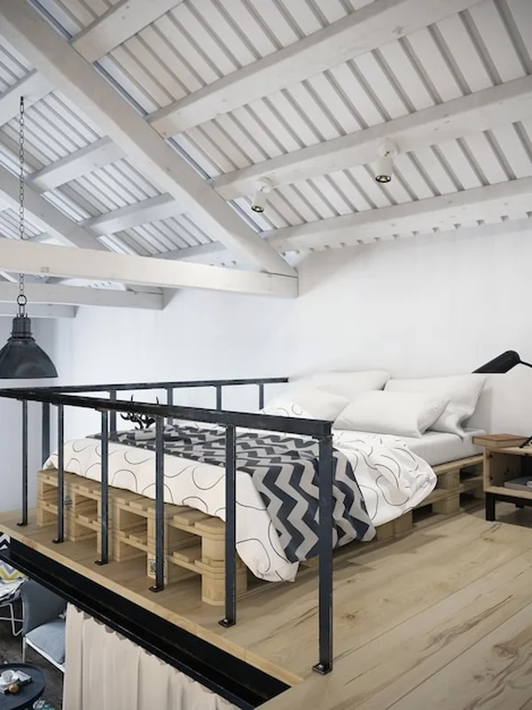Sypialnia na strychu z łóżkiem na paletach