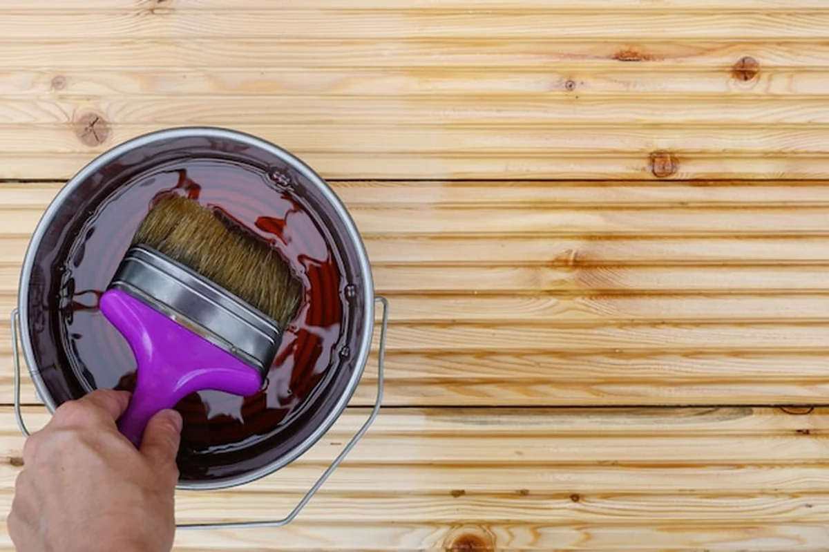 Malowanie nowych desek specjalnym olejem ochronnym na patio