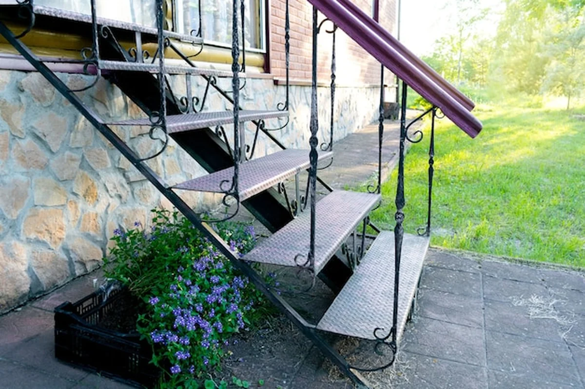 Metalowe schody w ogrodzie z trawnikiem wiosną