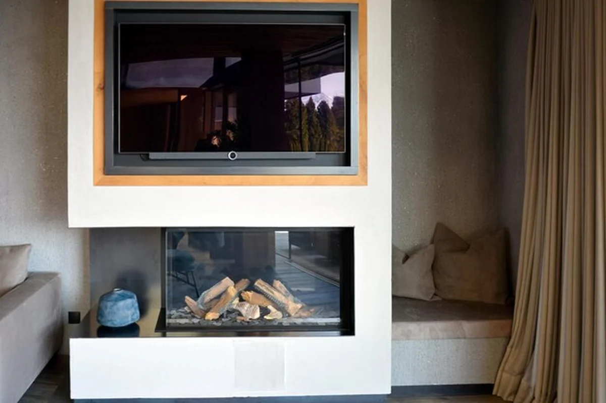 Salon z kominkiem w alkowie i telewizorem