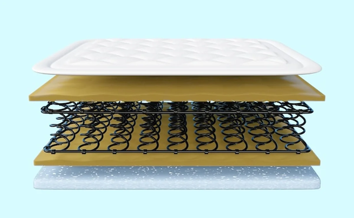 Warstwowy materac z różnymi materiałami na niebieskim tle